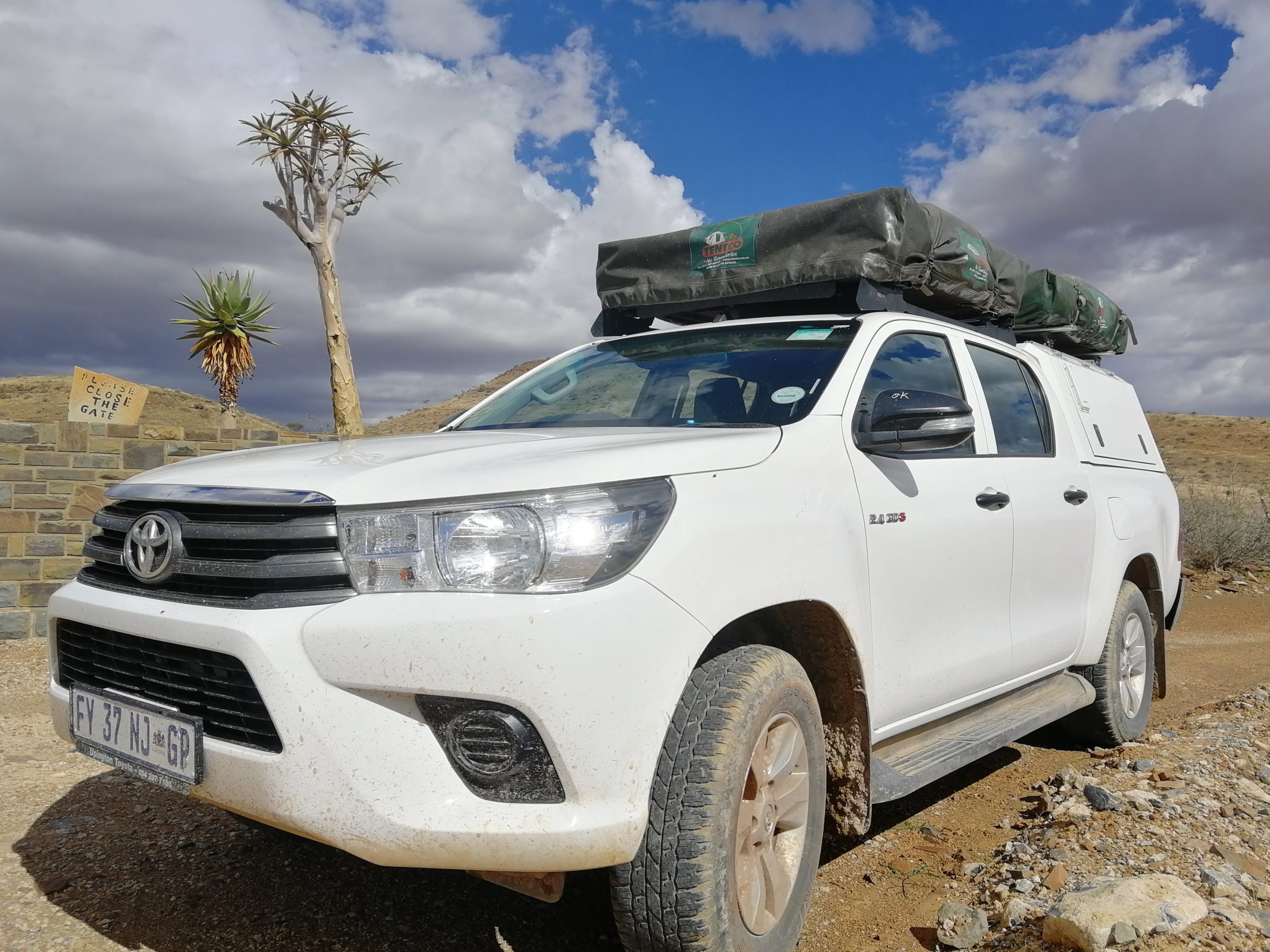 Nahansicht vom Toyota Hilux Double Cab mit 2 Dachzelten vor Eingang zum Naukluft-Park in Namibia