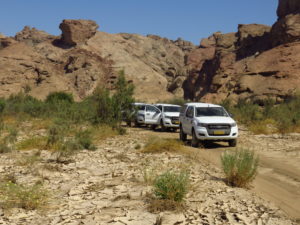 Kolonne von Allradfahrzeugen auf einer steinigen Piste Namibias