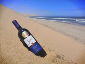 Strübin Pinot-Noir Weinflasche in den Dünen der Namib an der Atlantikküste