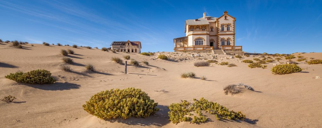 Blick aus der Wüste auf 2 verlassene Villen der ehemaligen Diamantenstadt Kolmanskop bei Lüderitz